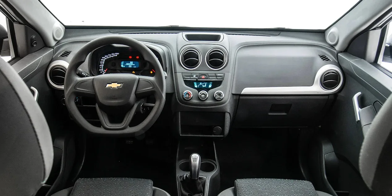 A cabine leva duas pessoas e aposta no essencial: ar-condicionado, vidros elétricos e banco do motorista com ajuste de altura.