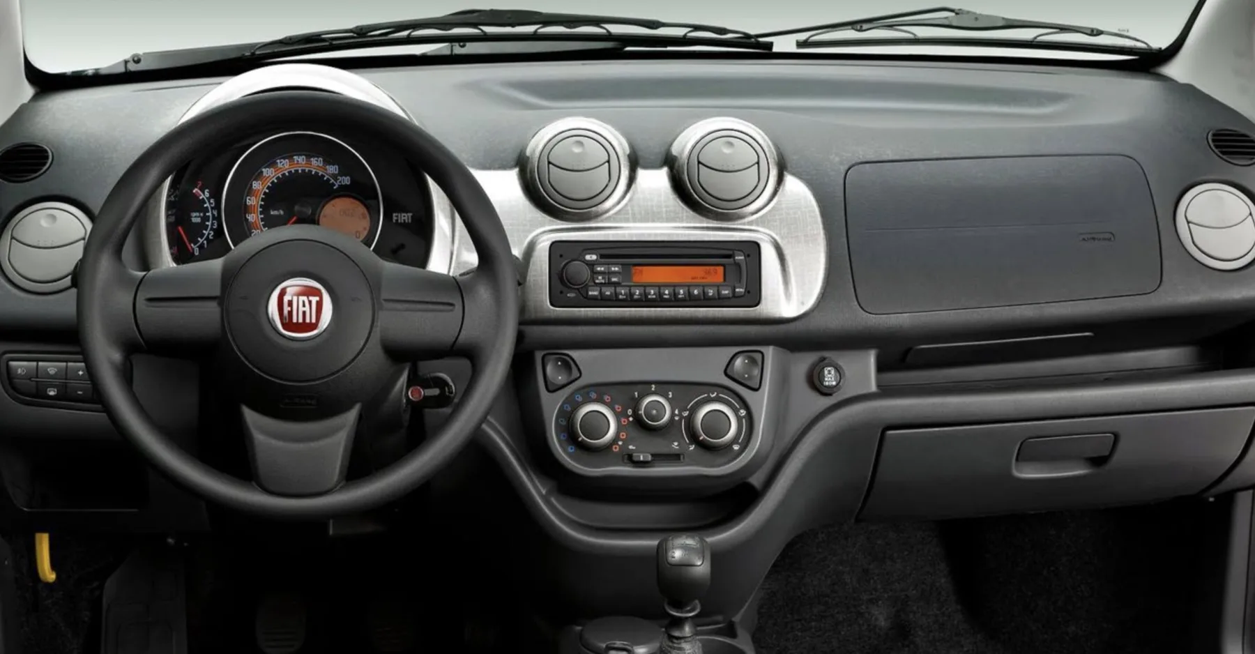 O câmbio manual de 5 marchas é simples, a tração dianteira previsível e a direção pede mais braço quando o carro não traz assistência.