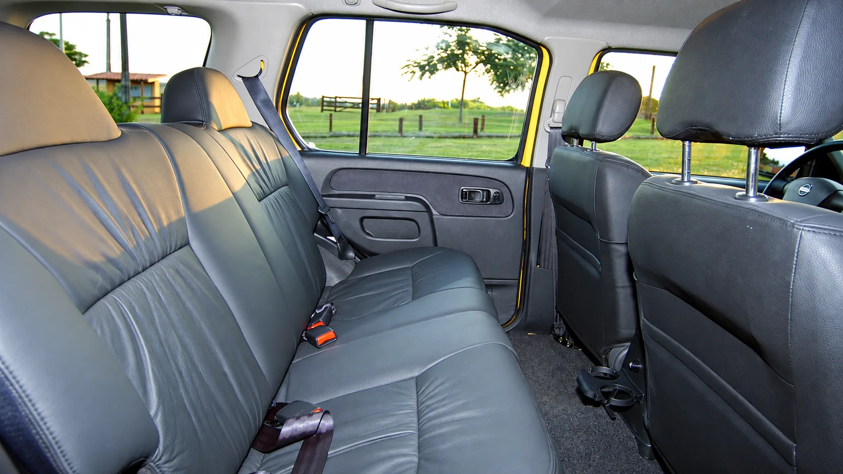 A cabine leva cinco pessoas, tem bancos de tecido e espaço honesto, mas o conforto lembra mais uma picape antiga do que um SUV moderno.