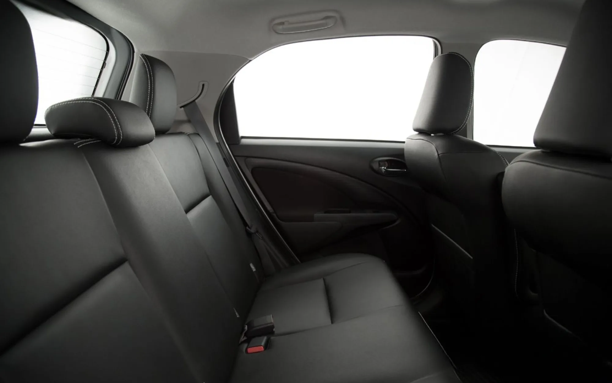 O interior acomoda cinco ocupantes, com direção elétrica, ar-condicionado, ajuste de volante e banco do motorista, além de freios ABS, airbags frontais e ISOFIX, oferecendo conforto funcional e segurança básica para a categoria.