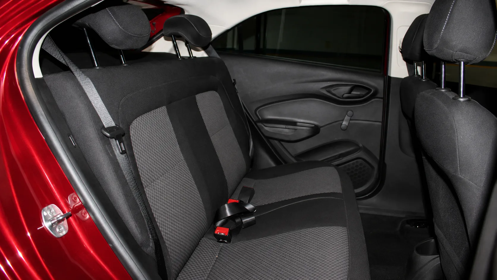 Atrás, o espaço atende melhor dois adultos, com cintos de três pontos e encostos de cabeça para todos; três passageiros viajam, mas o conforto cai em trajetos longos.