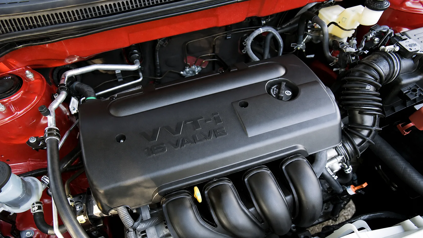 O motor 1.8 1ZZ-FE, aspirado e com VVT-i, entrega cerca de 136 cv nas versões a gasolina. É simples, suave e conhecido por aguentar quilometragens bem elevadas.