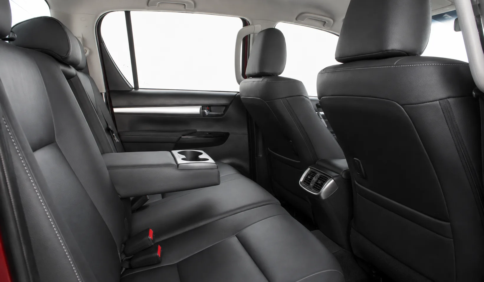 Atrás, a Hilux leva três ocupantes e oferece banco de couro, ar-condicionado e bom acesso pelas quatro portas, mas a traseira com feixe de molas cobra conforto em viagens longas.